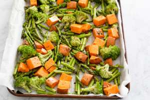 sweet potatoes, broccoli and asparagus on cookie sheet