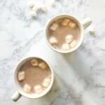 2 mugs with hot cocoa and marshmallows