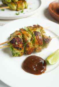 A plate of hara masala chicken skewers with some tamarind/imli chutney and lime wedge