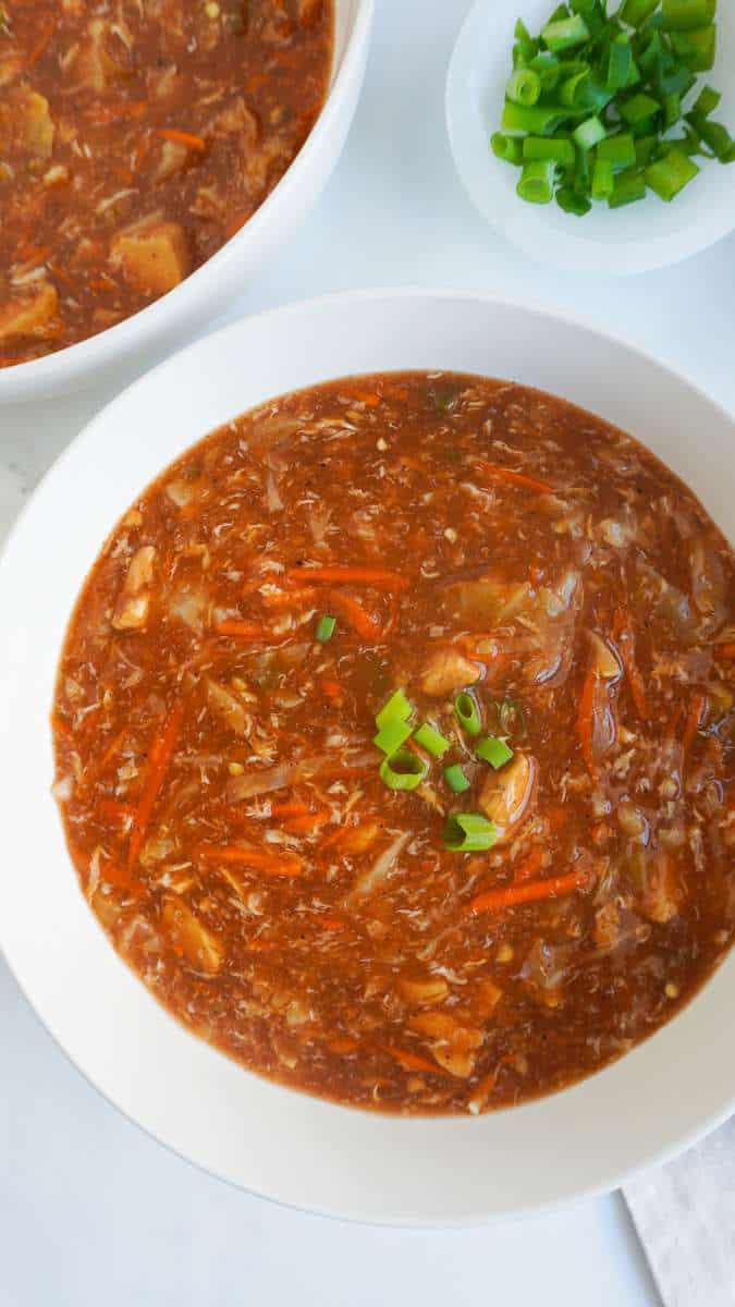 Hot and sour soup in bowls and green onion garnish