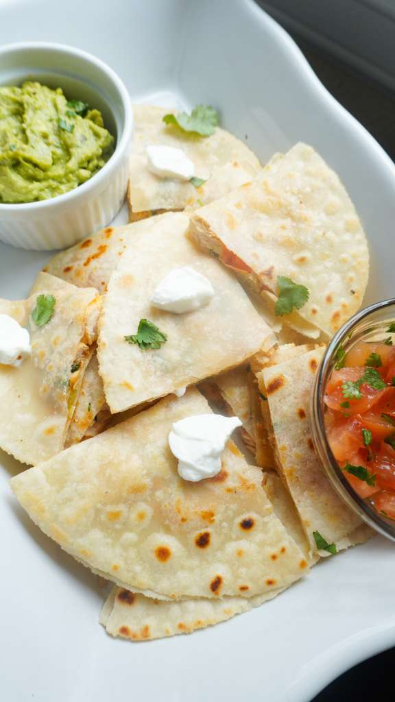 quesadillas in a platter with guacamole and salsa