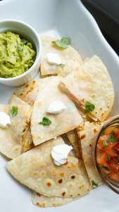 mini quesadillas in tray with avocado dip and salsa