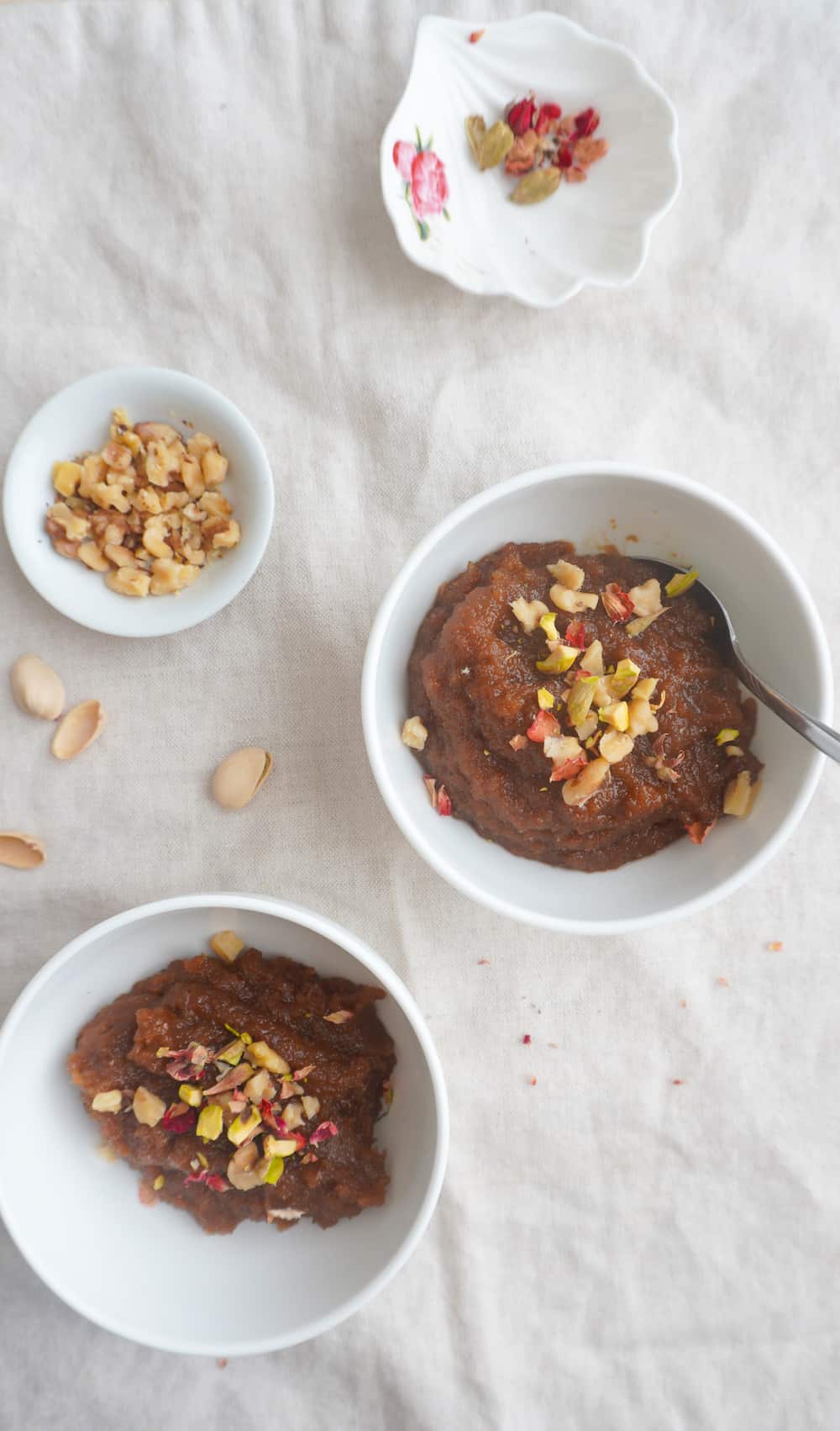 2 bowls of almond halwa with 2 dipping bowls with garnish