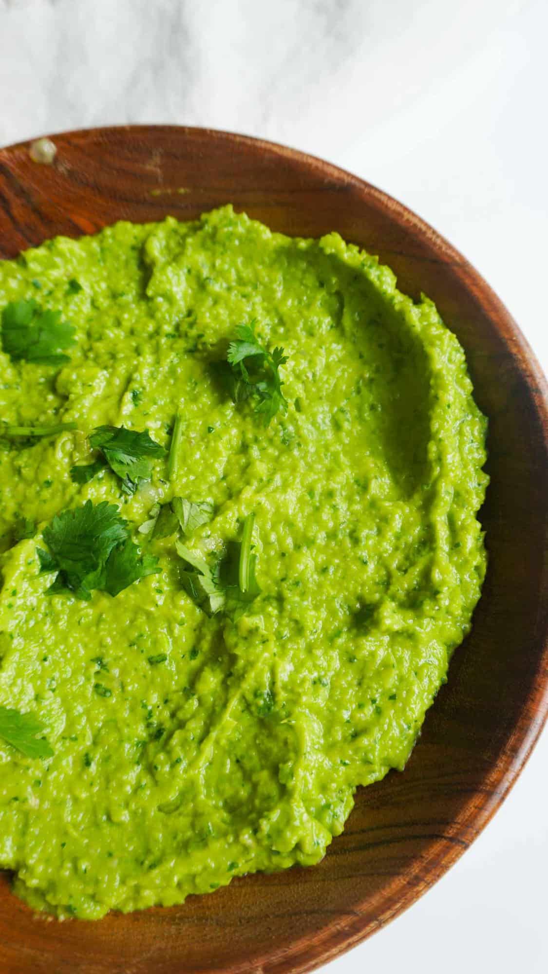 Close up of sweet pea green chutney dip in a wooden bowl