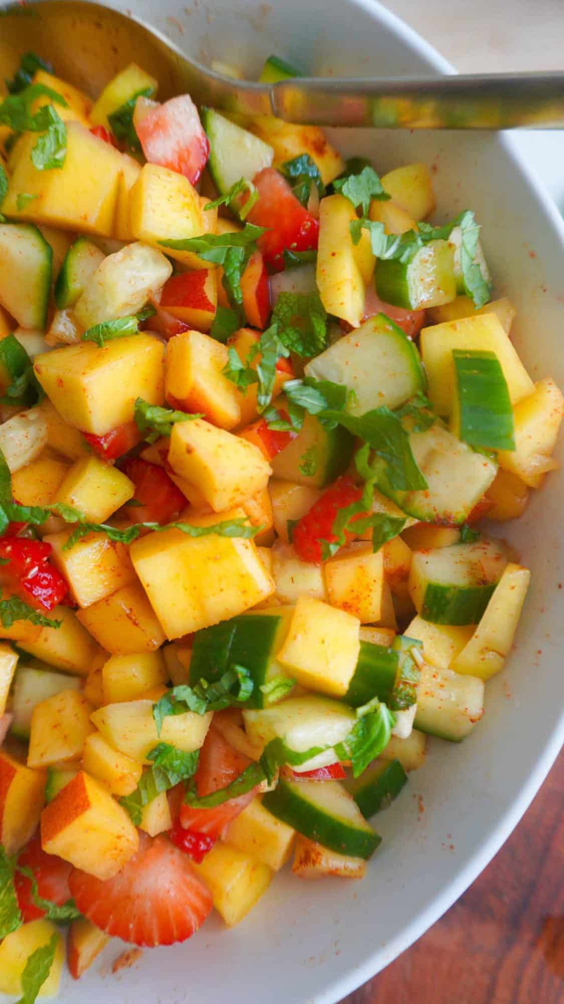 Chopped mango chaat in a bowl with spoon