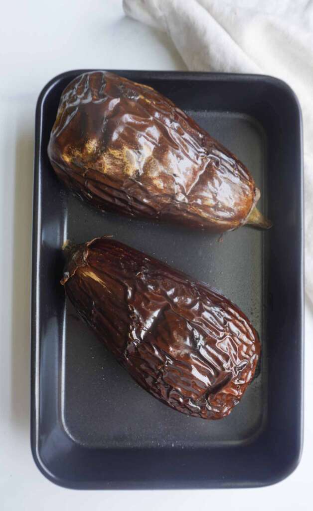 2 roasted eggplants in black oven roasting pan