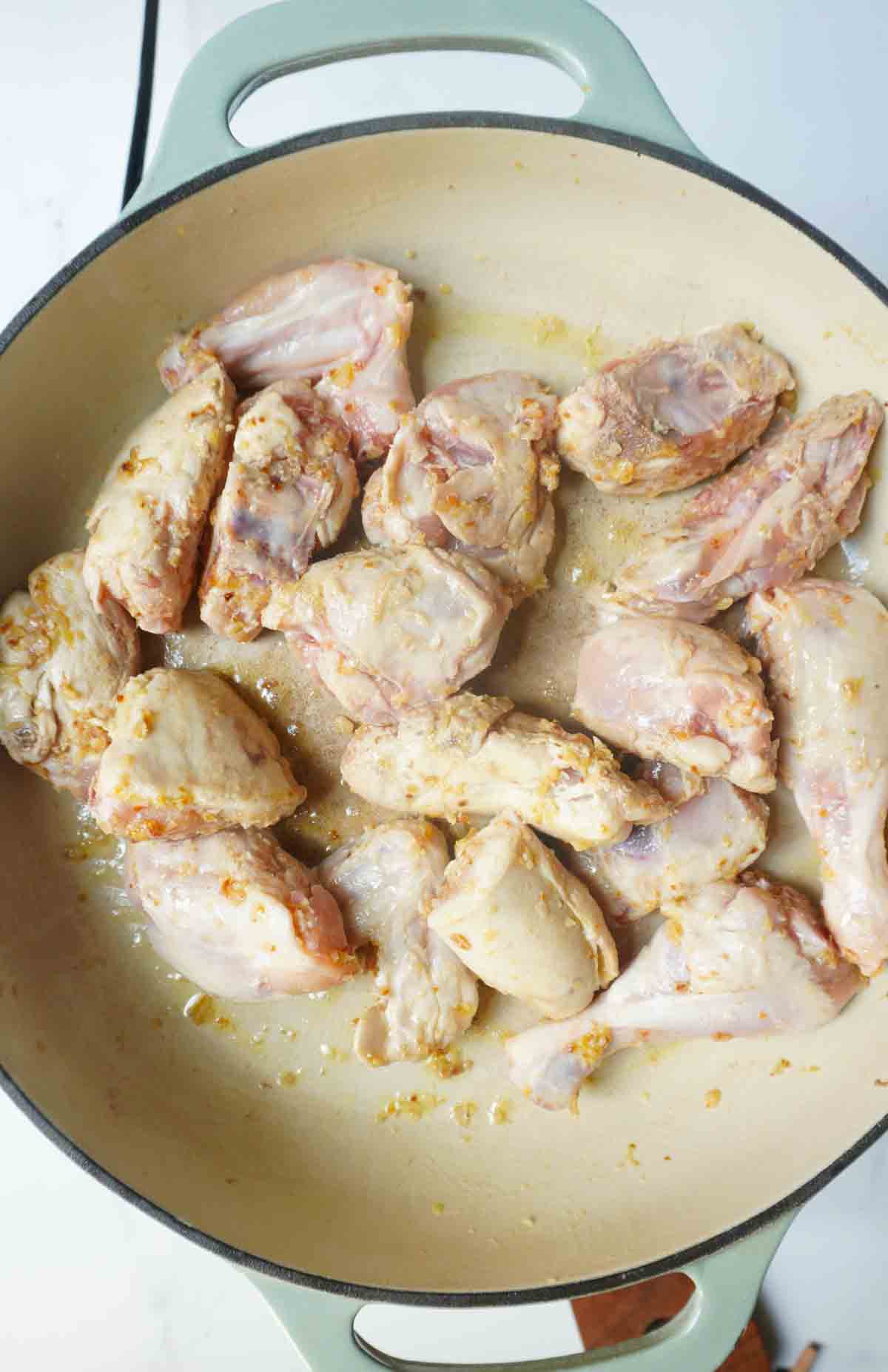 arial shot of raw chicken cooking with ginger and garlic