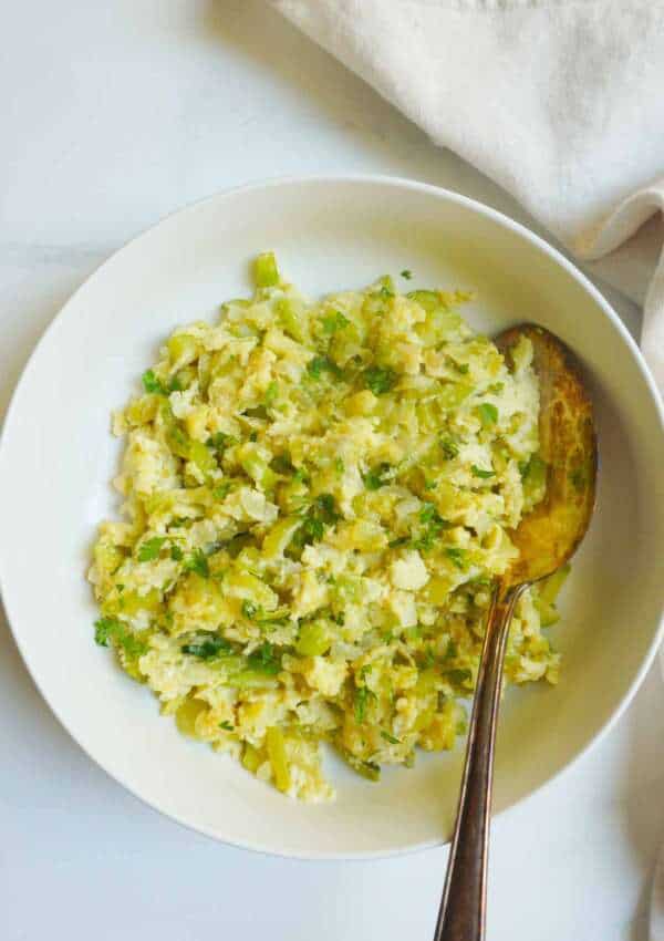 flat lay of zucchini curry in a dish woth a spoon