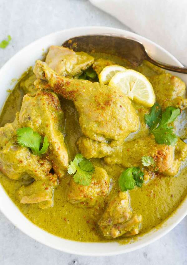 Hariyali chicken curry in serving bowl and a spoon