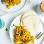 khagina in 2 plates with pita bread and forks.