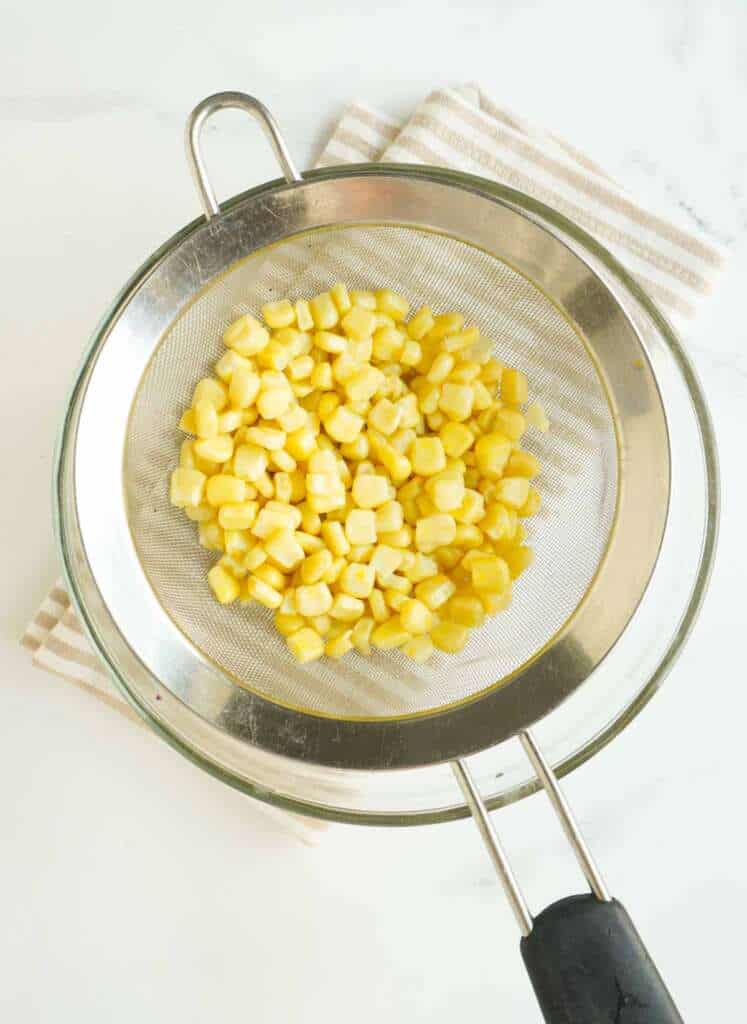 A bowl with corn on strainer