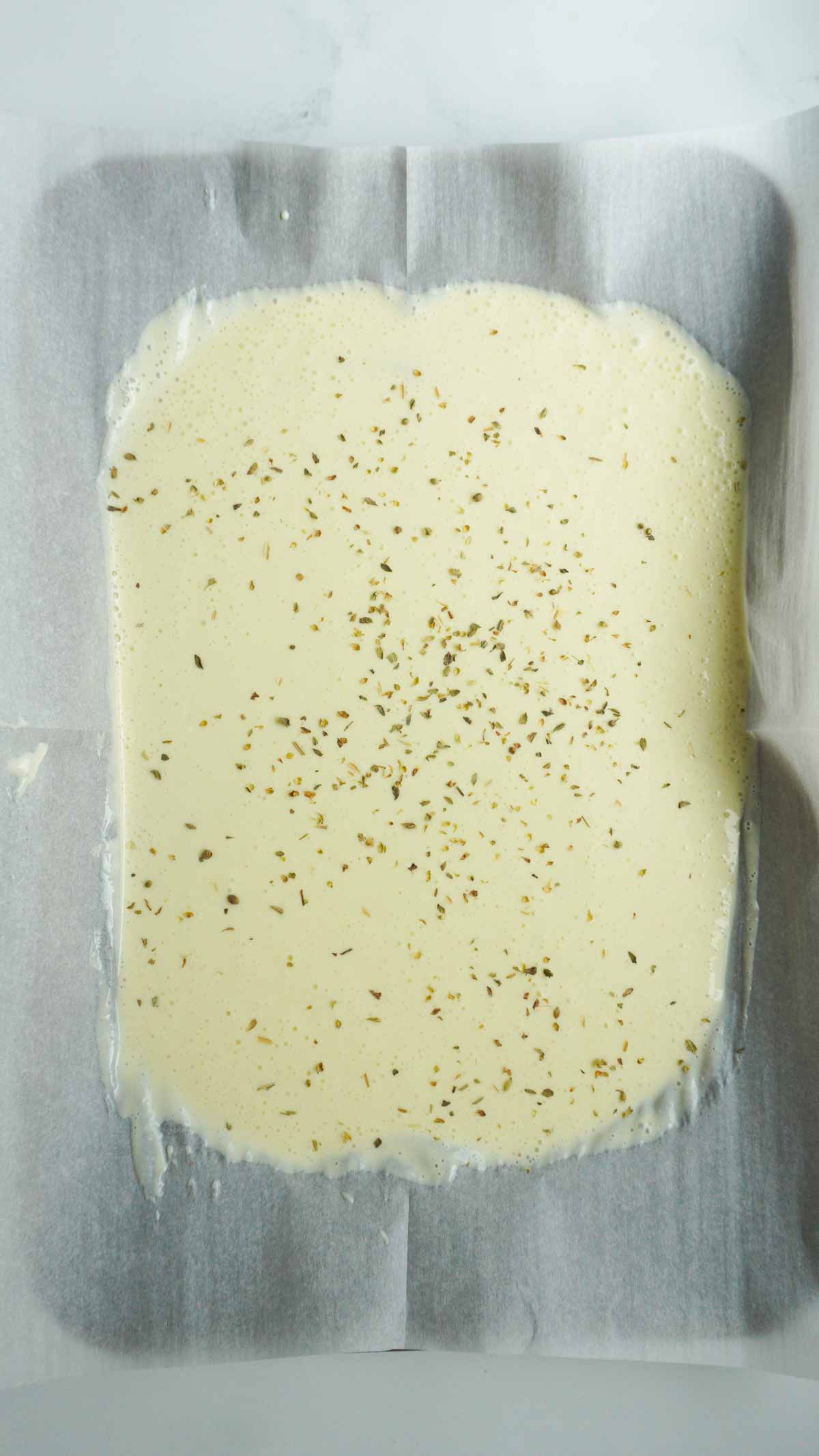 uncooked 2 ingredient cottage cheese flatbread in parchment lined sheet pan