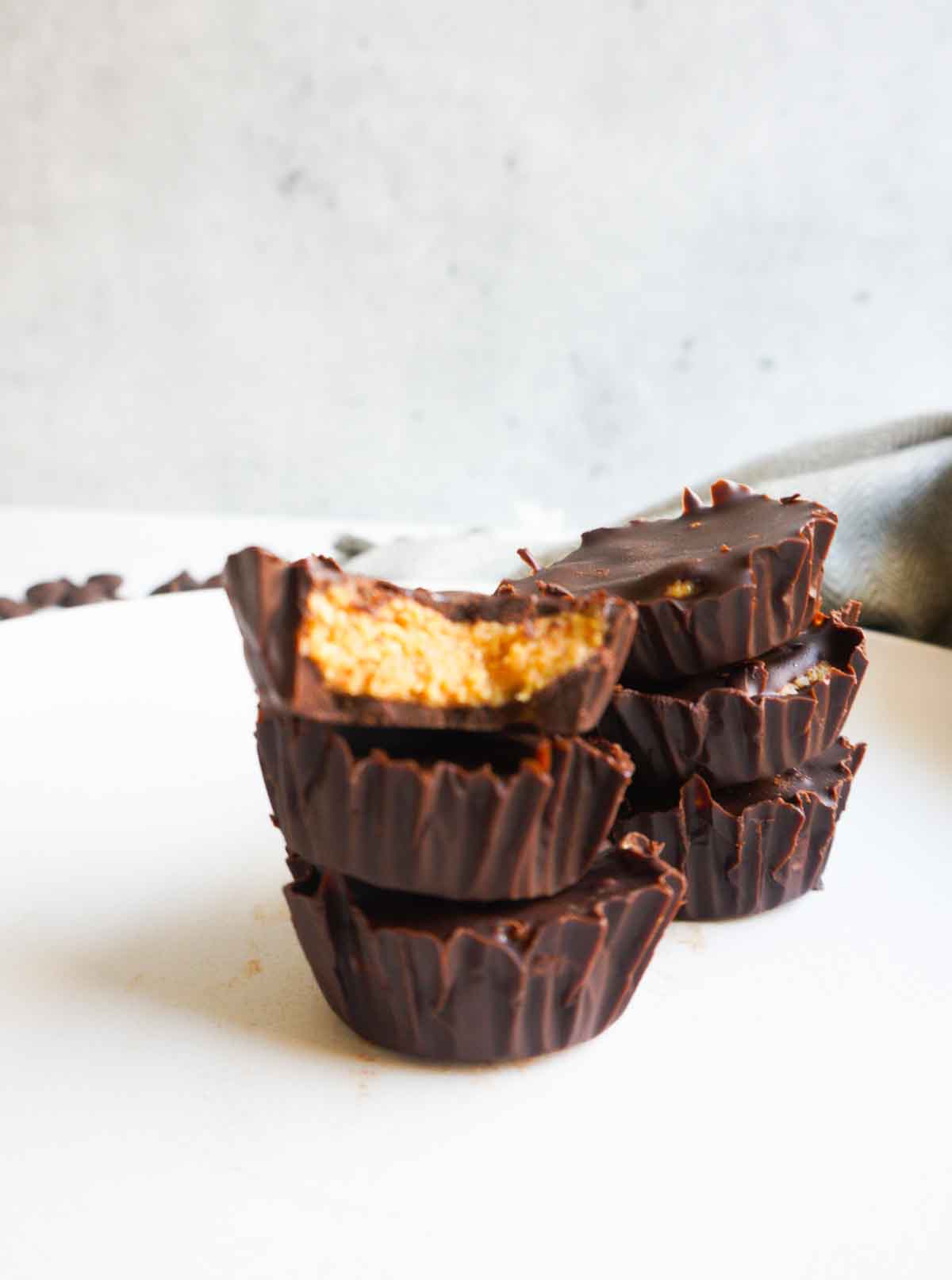stack of three low carb dark chocolate peanut butter cups with some more in the back ground