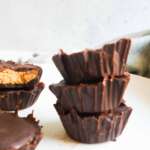 3 stacked healthy peanut butter cups with some more in the back ground