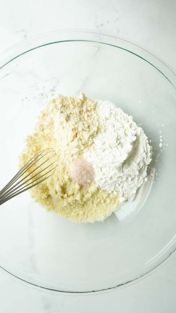 a bowl with gluten free flours, salt and a whisk