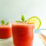 2 glasses of watermelon juice with lime and mint garnish