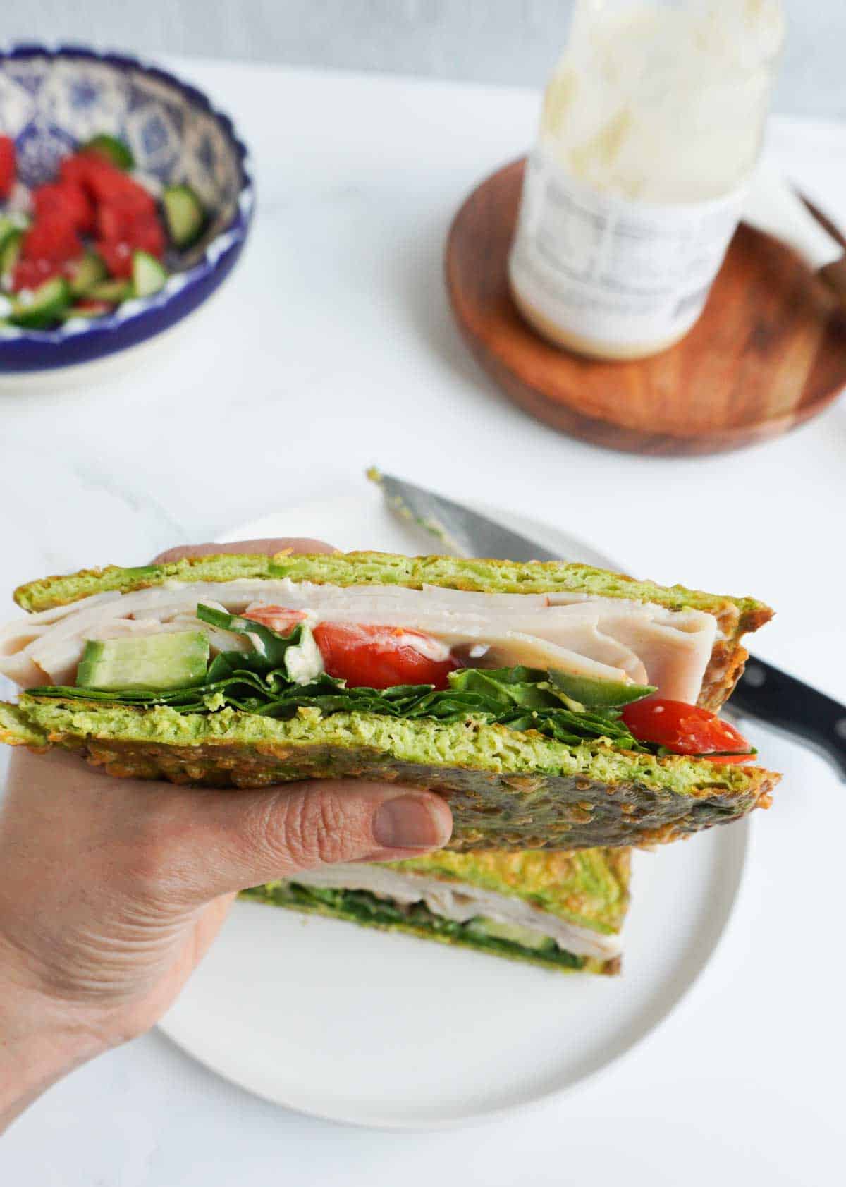 a hand holding half a sandwich 