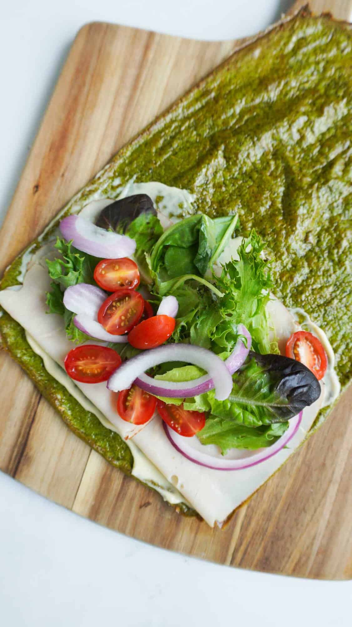Open spinach cottage cheese flatbread with turkey, greens, onions and tomatoes
