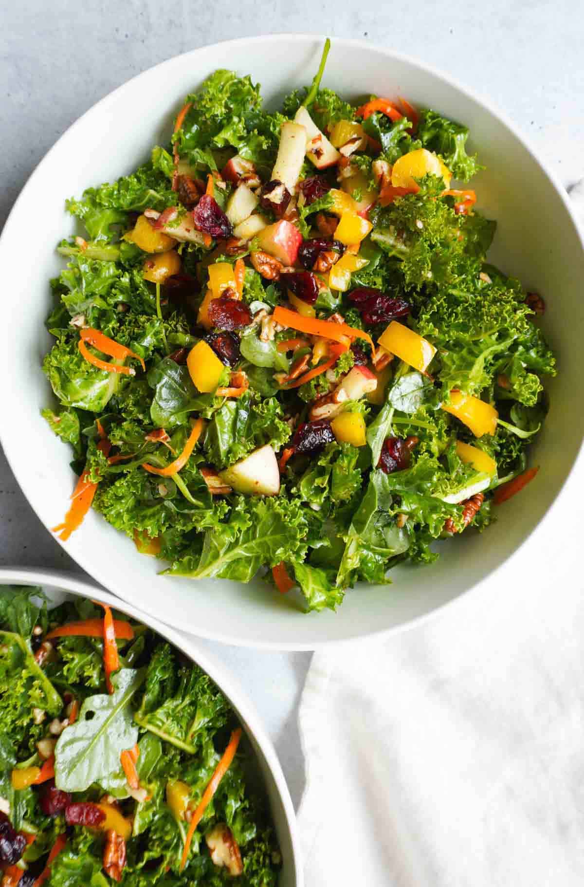 Two bowls of kale salad and a napkin