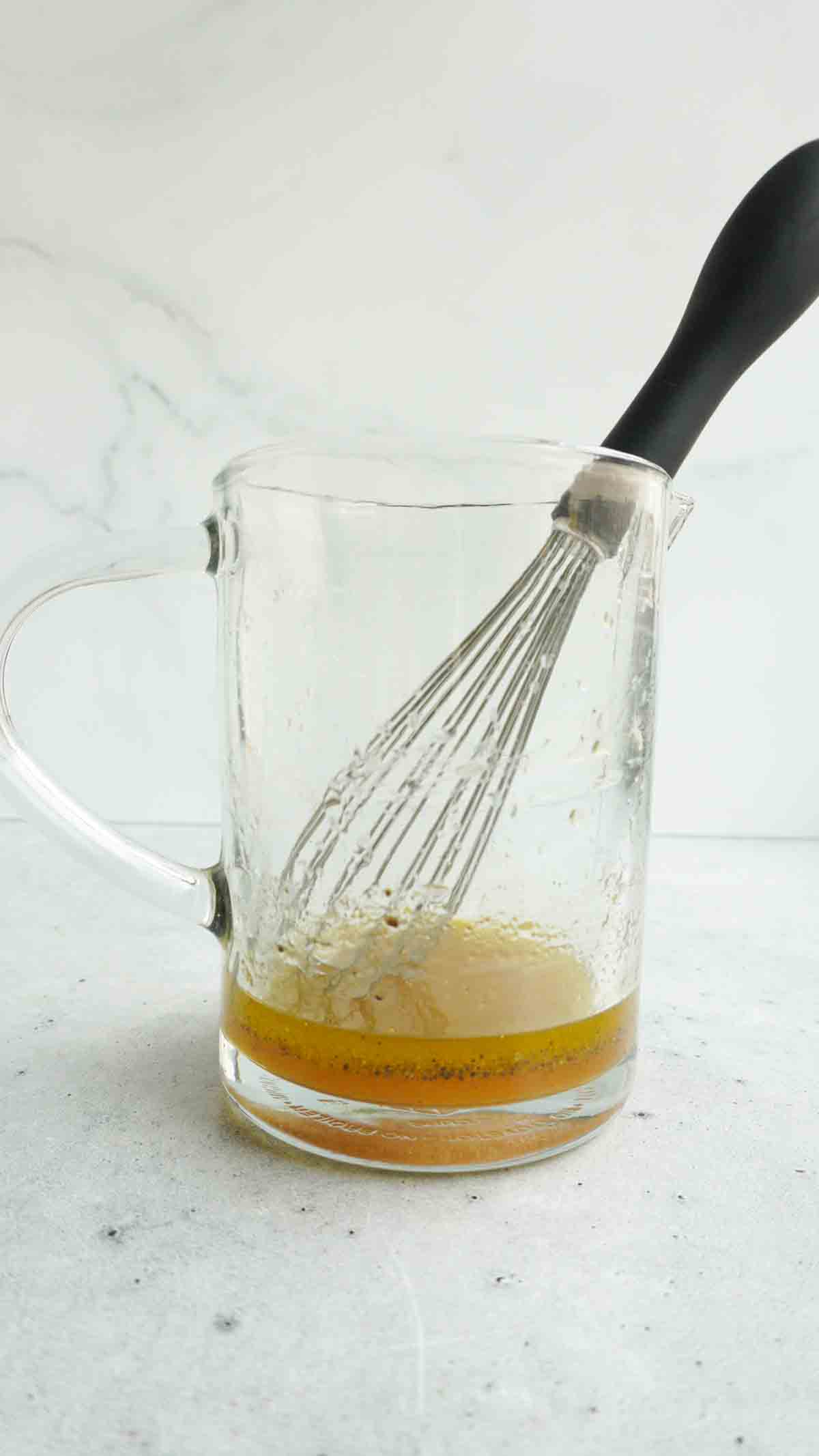 dressing in a measuring jug with whisk