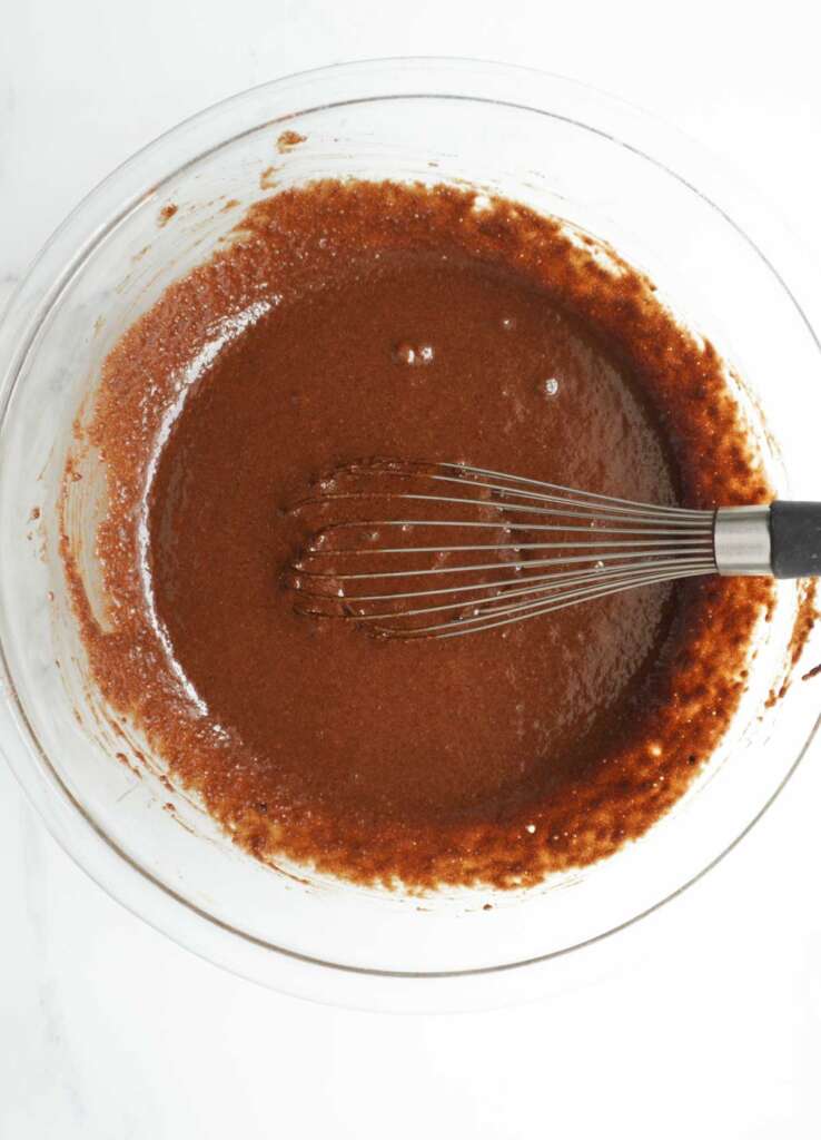 almond flour chocolate cake batter in a bowl with a whisk