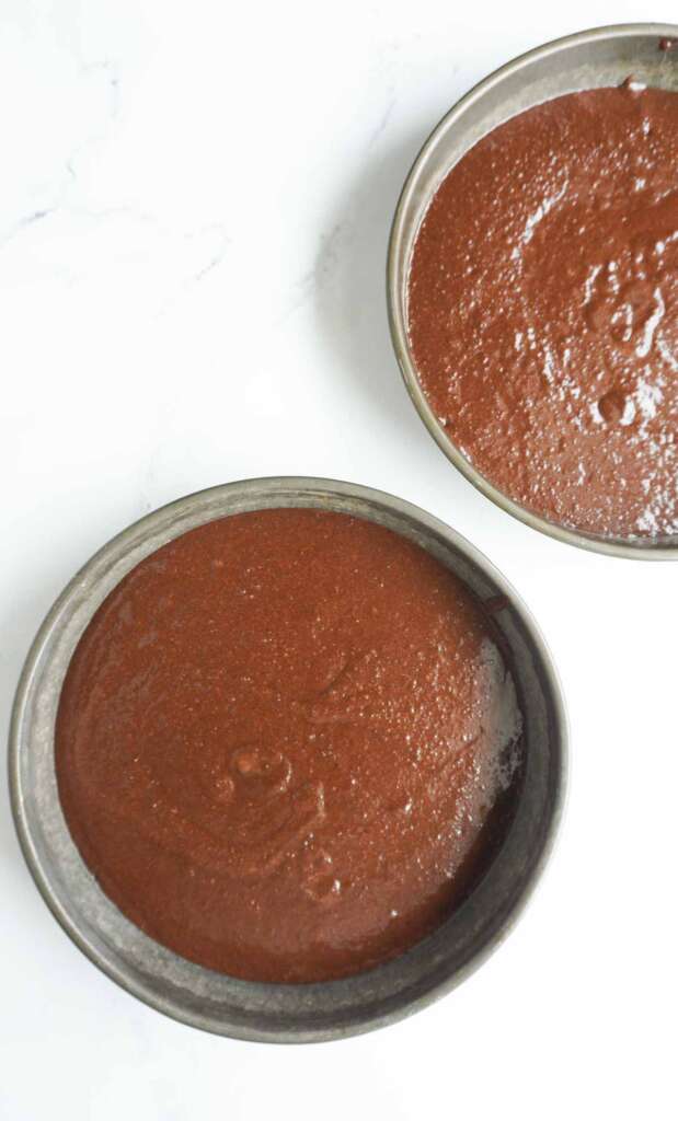 raw almond flour chocolate cake batter in round cake pans
