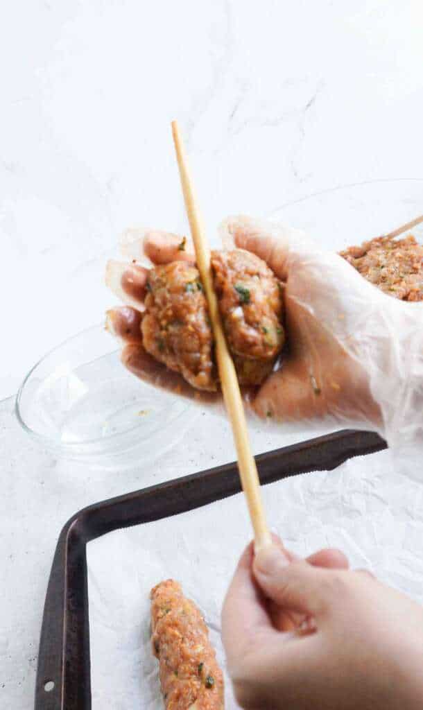A chopstick wedged between a ground chicken kebab