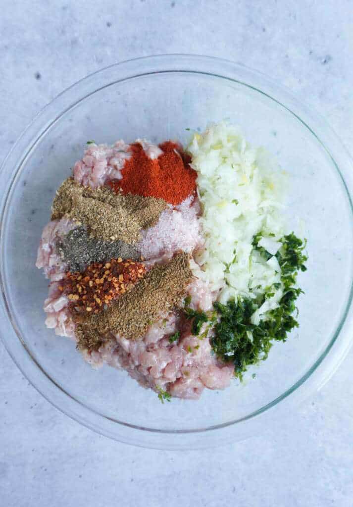 A bowl with ground chicken, onions and spices