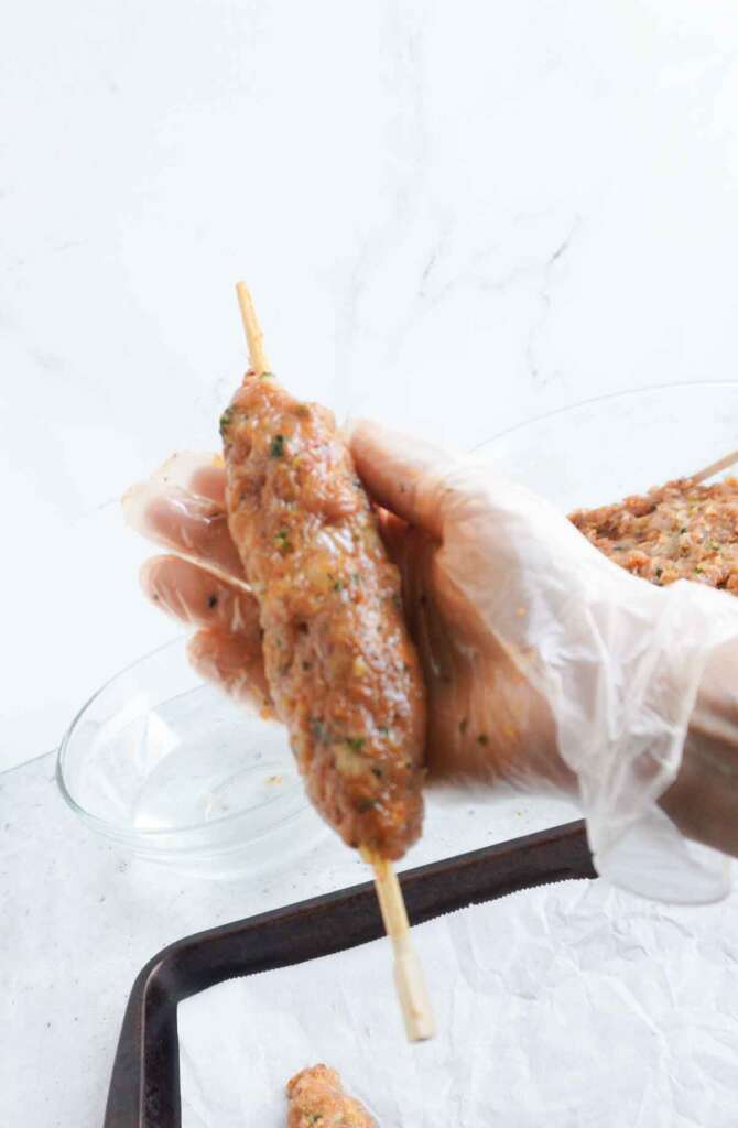 A chicken seekh kebab on a wooden chopstick