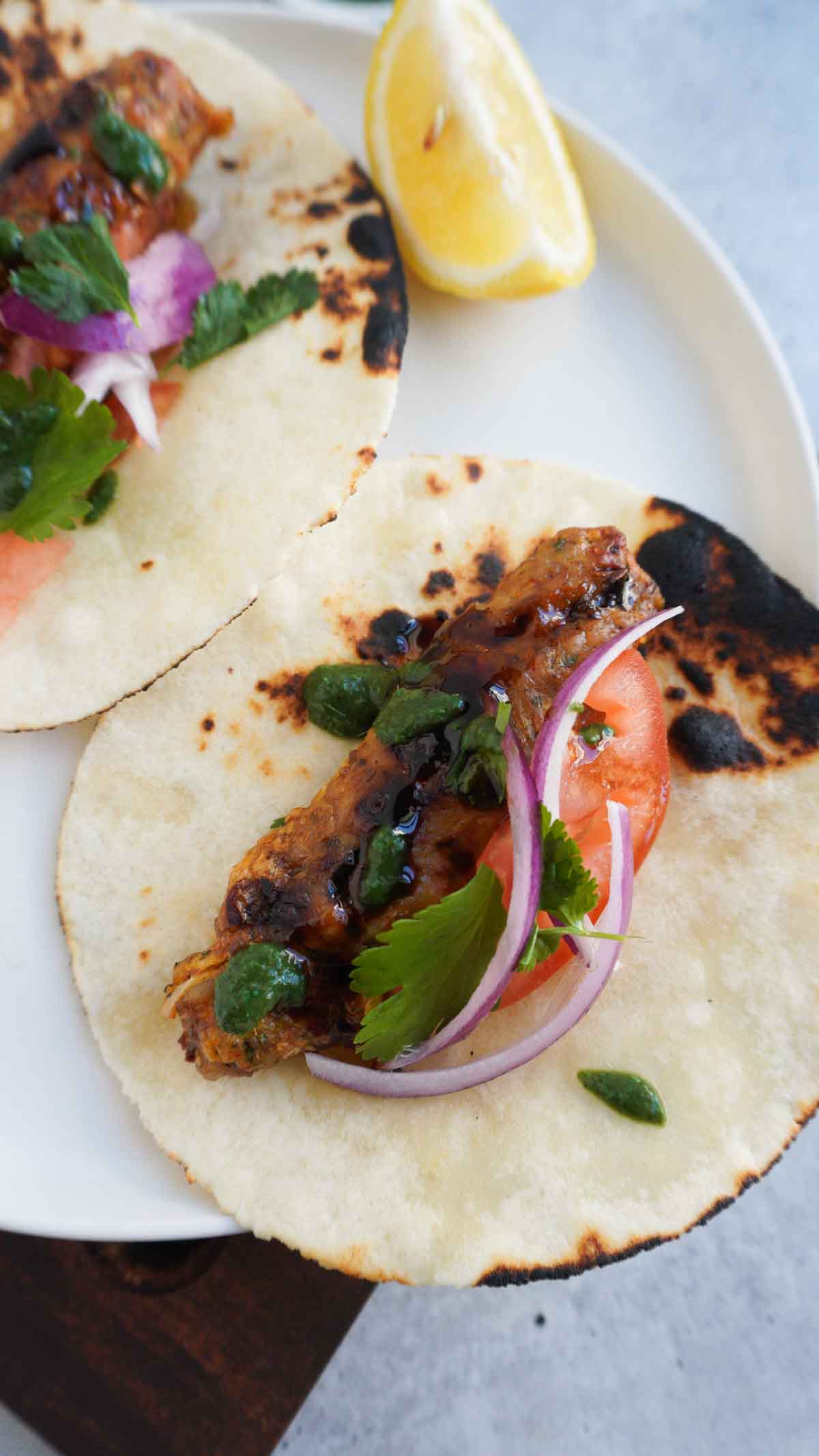 chicken seekh kebab in a wrap with onion and tomatoe salad and chutney