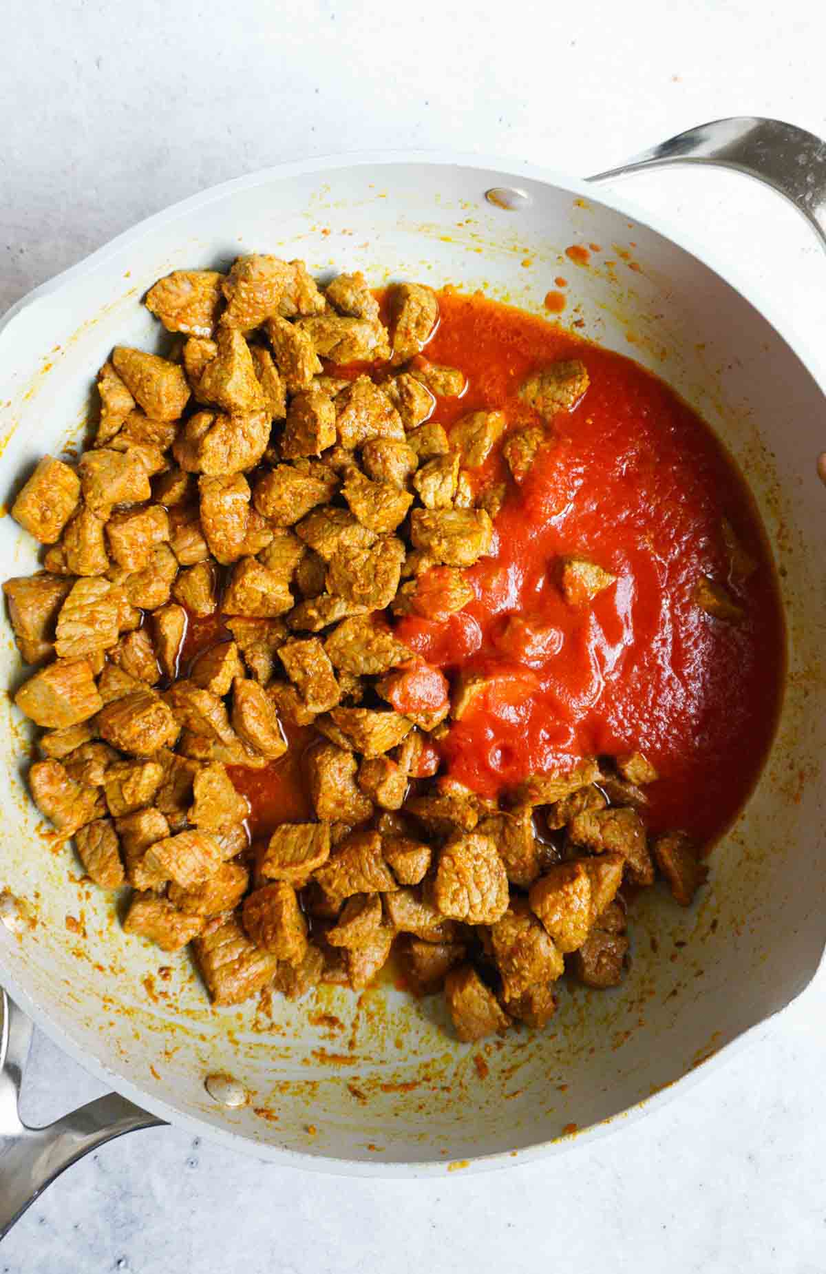 Spiced beef with tomato passata in a pan