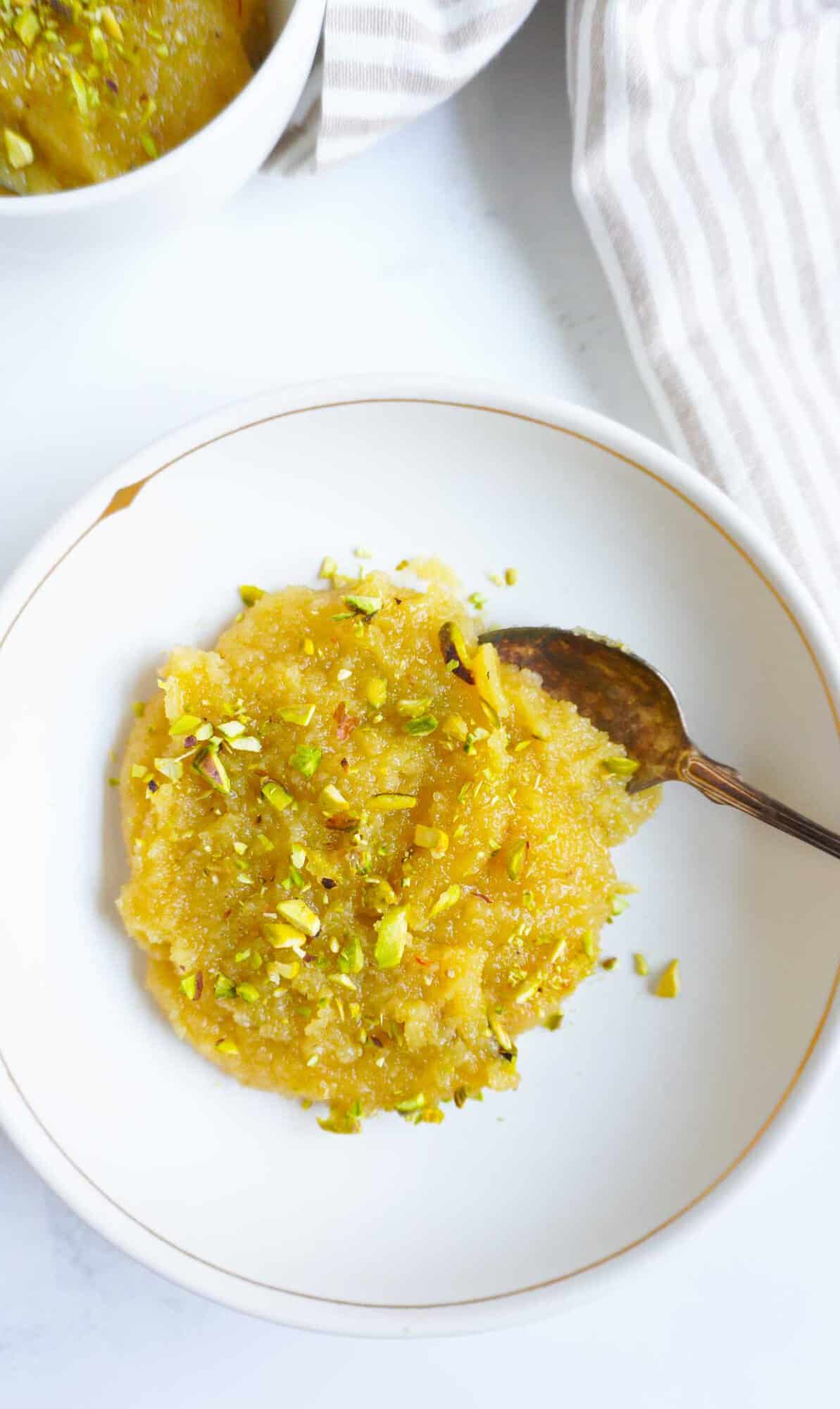A bowl of almond halwa with pistachio garnish