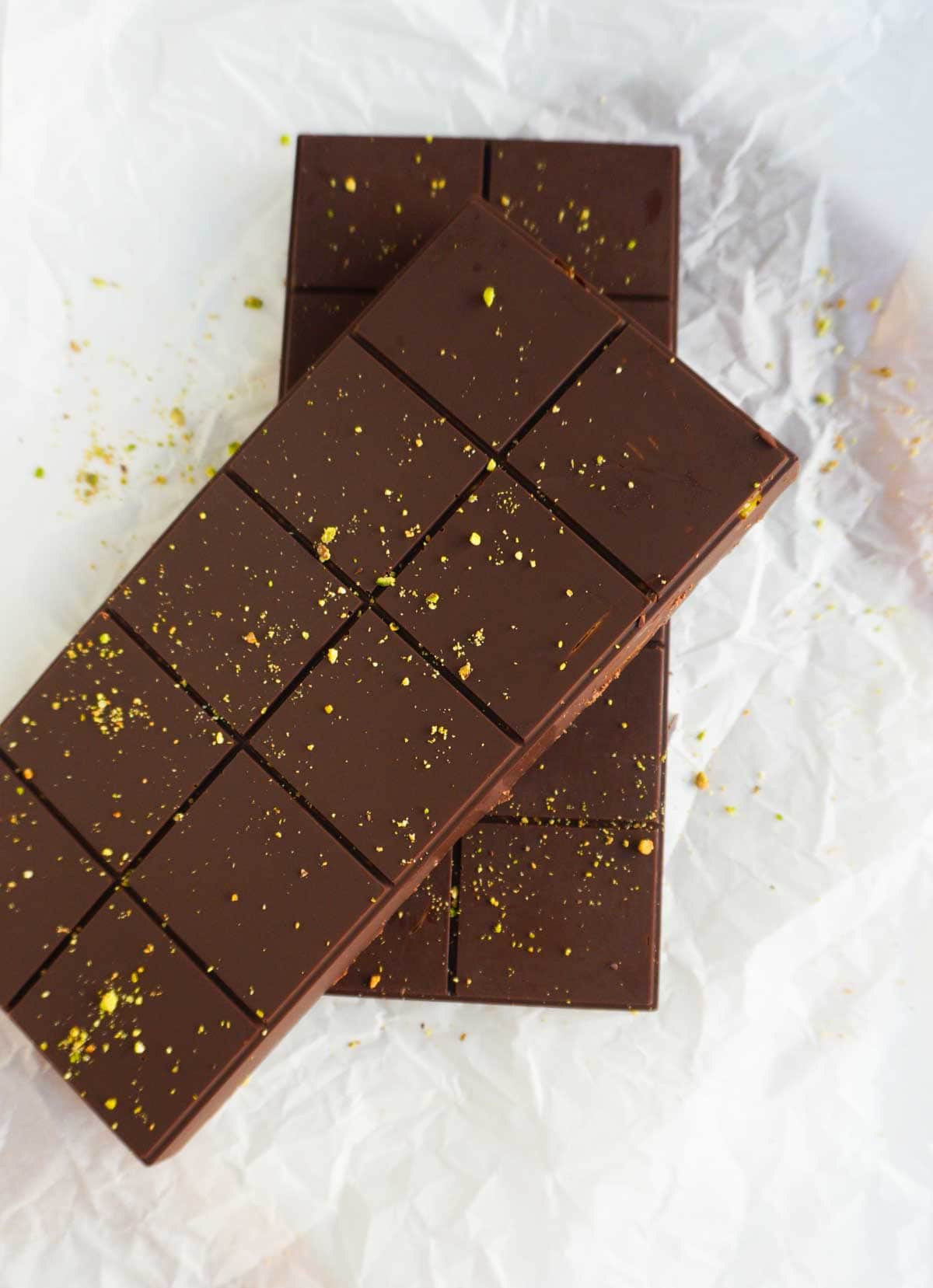 2 gluten free Dubai chocolate bars on parchment with crushed pistachios sprinkled on top