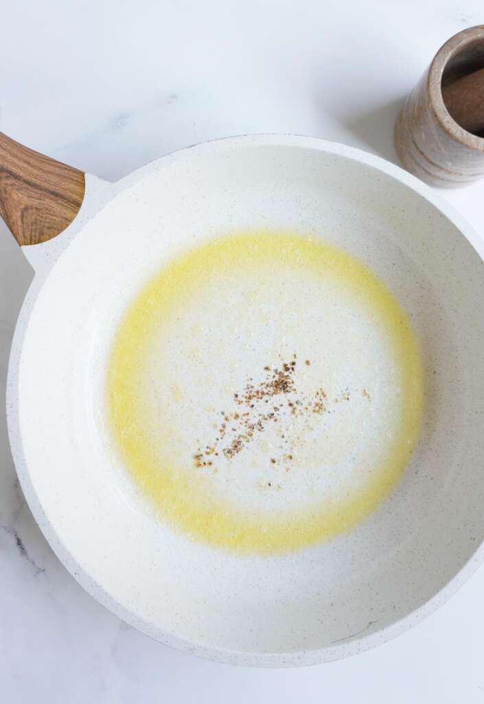 melted butter and crushed cardamom seeds in pan.