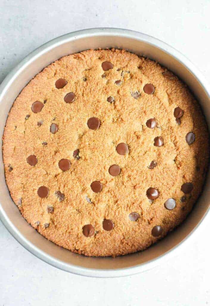 A chocolate chip cookie cake in a pan.