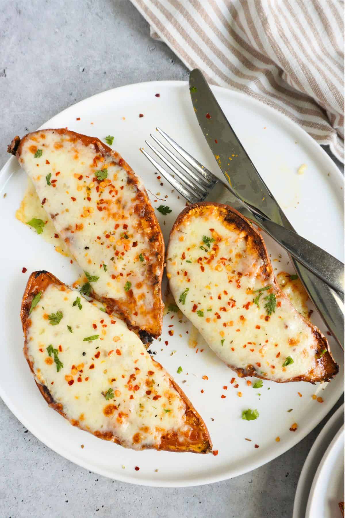 Sweet potato mozzarella halves on a white plate on a light background.