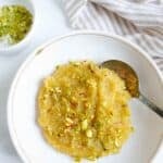 Almond halwa in a white plate over a light background.